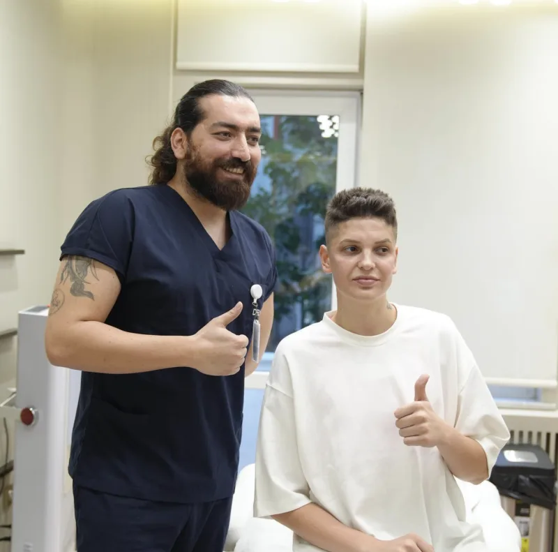 Dr. Ömer Erdoğan hastasıyla klinikte, başparmak işareti
